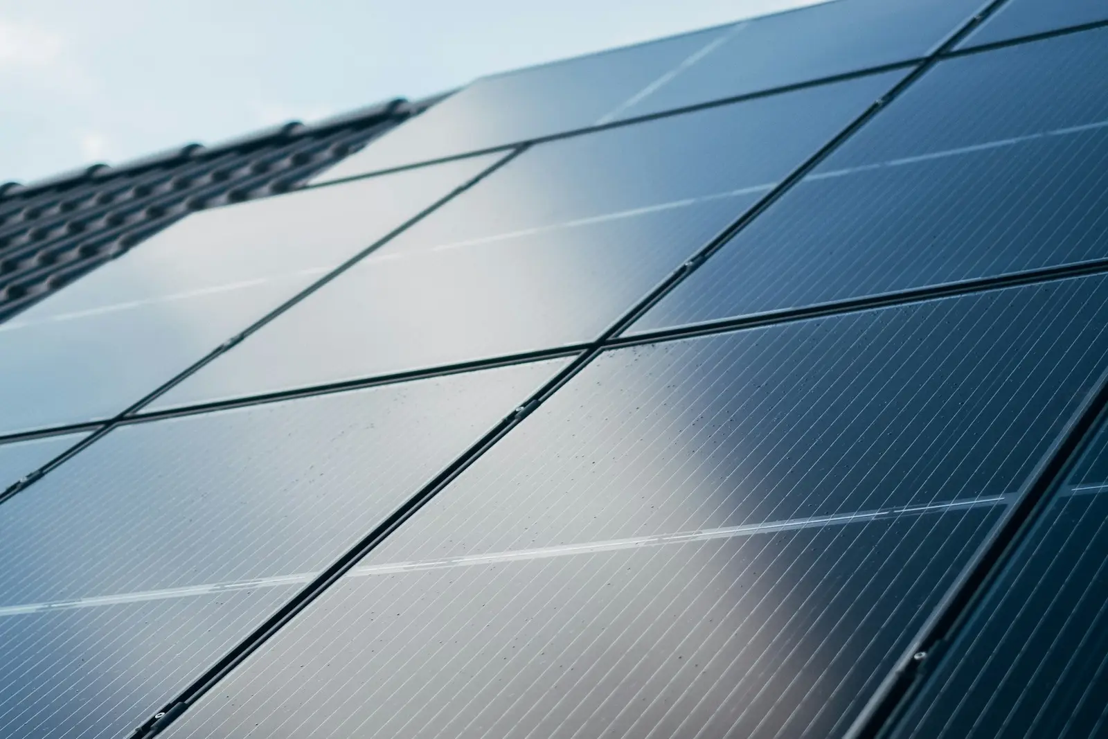 Close-up van donkere zonnepanelen op een dak in het zonlicht