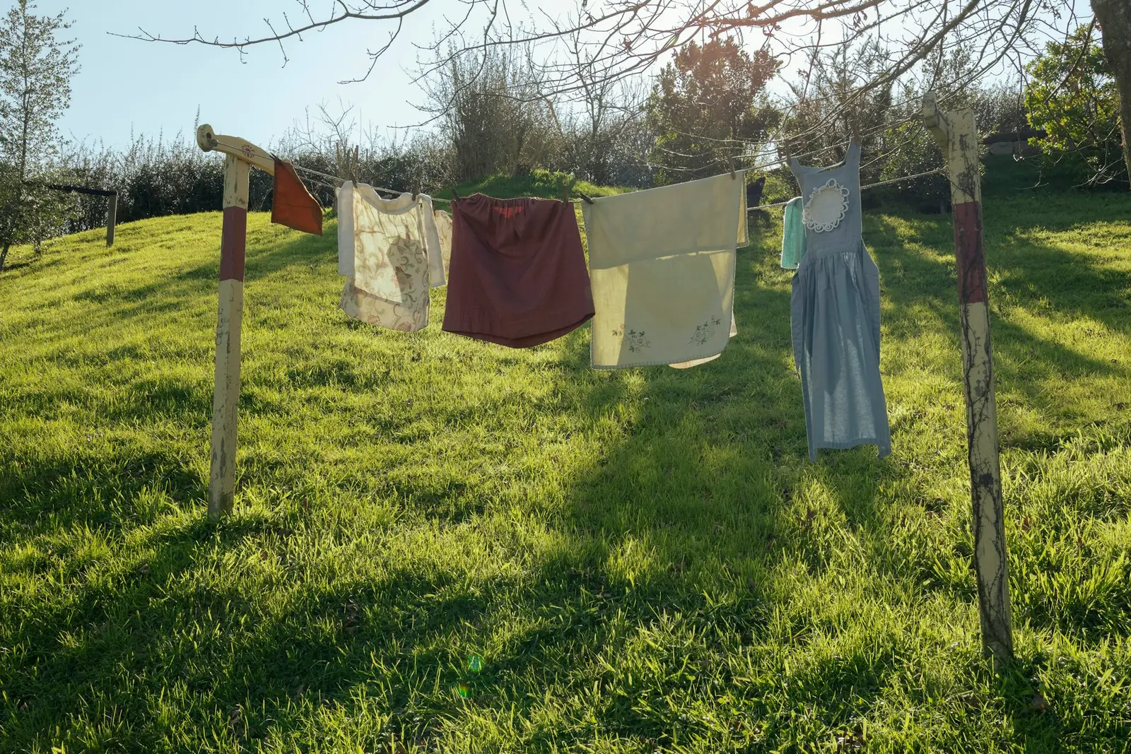 Was aan een waslijn tussen houten palen op een grasveld in de zon
